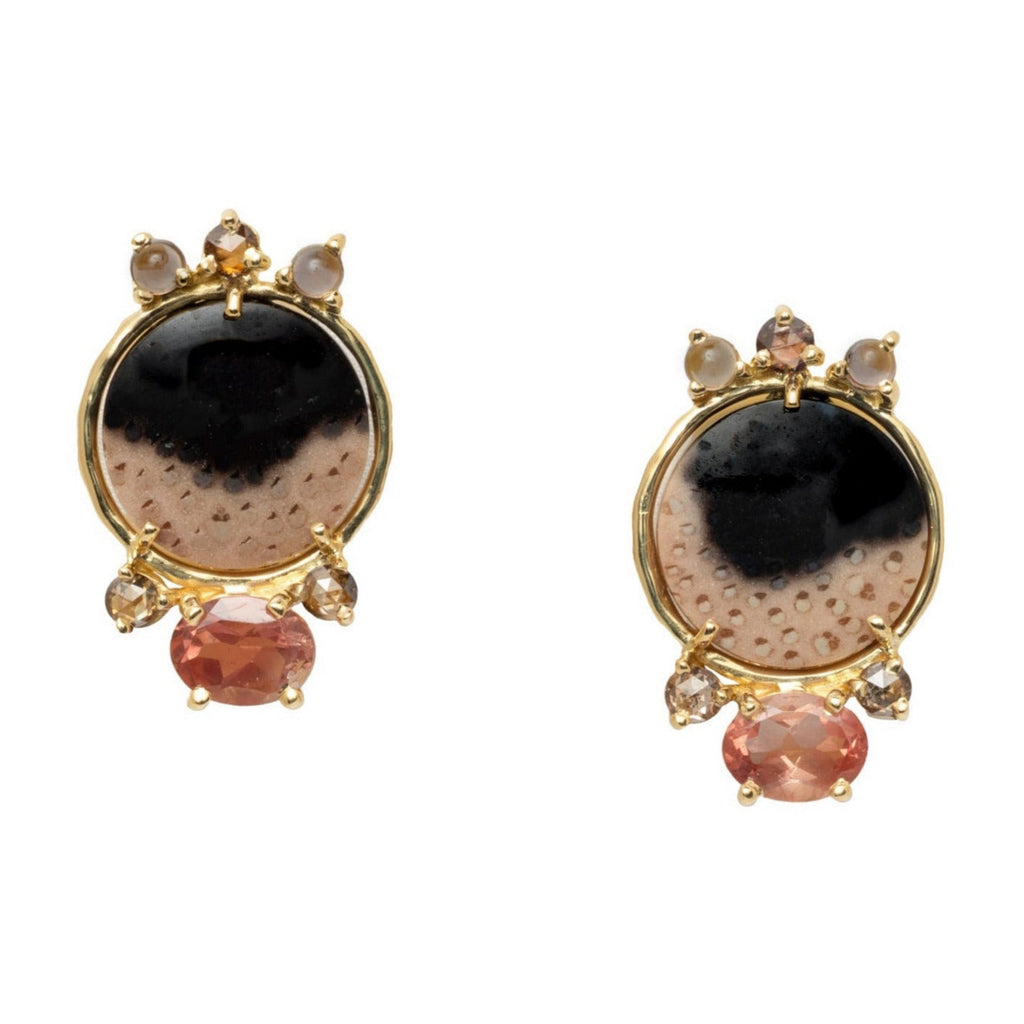 Pair of earrings with black, brown and peach-colored stones set in yellow gold on a white background