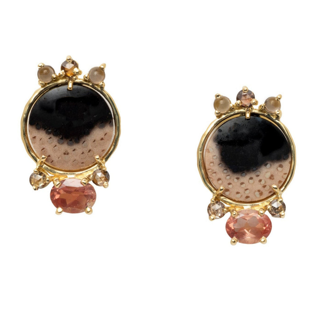 Pair of earrings with black, beige and peach design set in yellow gold on a white background