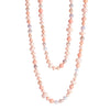 A long necklace of coral, freshwater pearls, and peach opal with a tri-cornered freshwater pearl clasp set in 18k yellow gold.